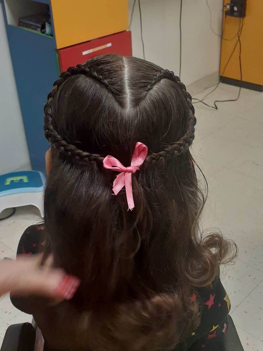 Braided half-up style with a pink bow