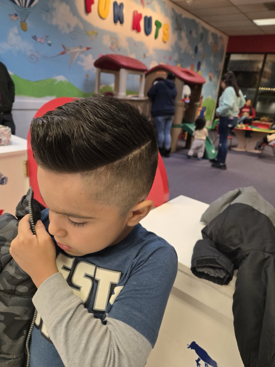 A boy with a fresh fade and side part
