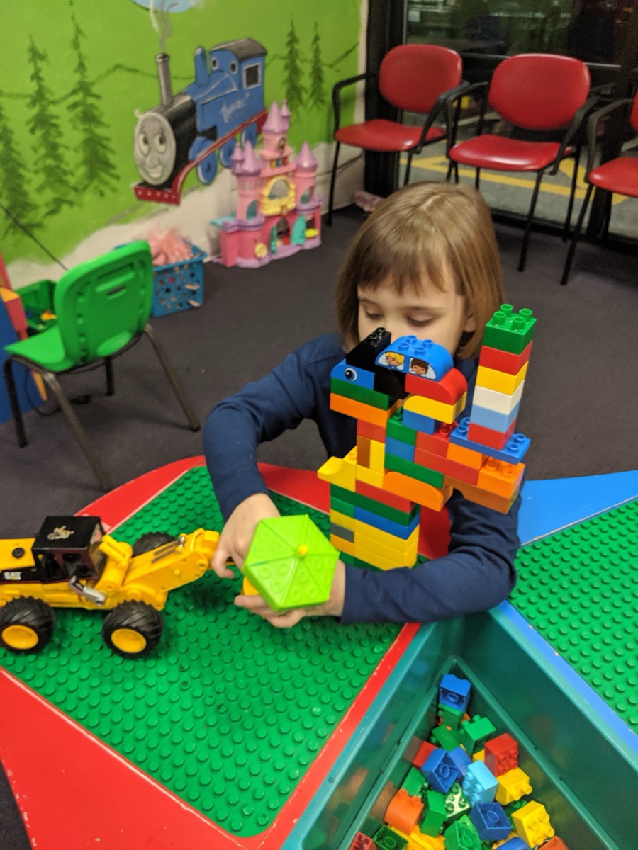 A girl building with blocks in the play area